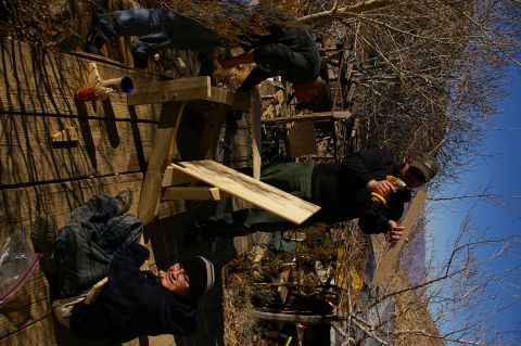 1986 Ford Bronco - Several individuals are engaged in constructing a wooden frame outdoors on a sunny day.