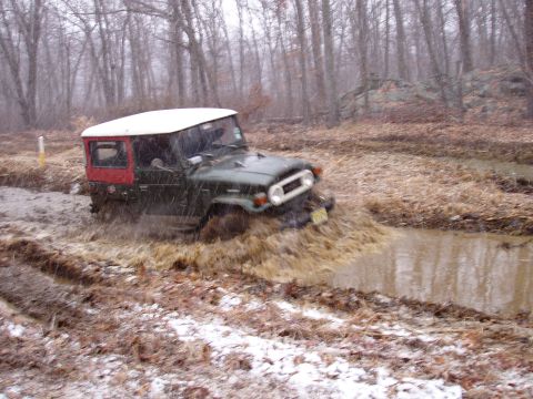 1976 Toyota Land Cruiser - This 1976 Toyota Land Cruiser navigates a challenging muddy terrain during what appears to be a snowy or wet day.