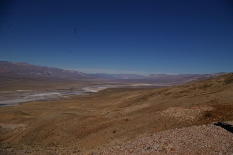 1986 Ford Bronco - A vast, arid valley stretches towards distant mountains under a bright, cloudless sky.