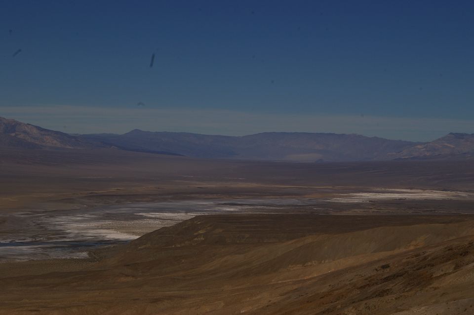 Vast desert landscape with mountains under a clear blue sky