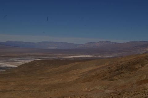 1986 Ford Bronco - Expansive desert scenery with rolling hills in the foreground and mountain ranges in the distance.
