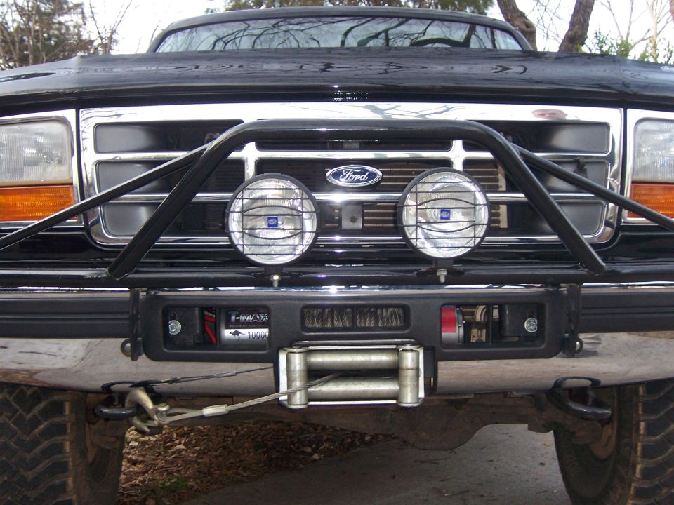 Black Ford Bronco front end with chrome grille, bull bar, winch, and fog lights