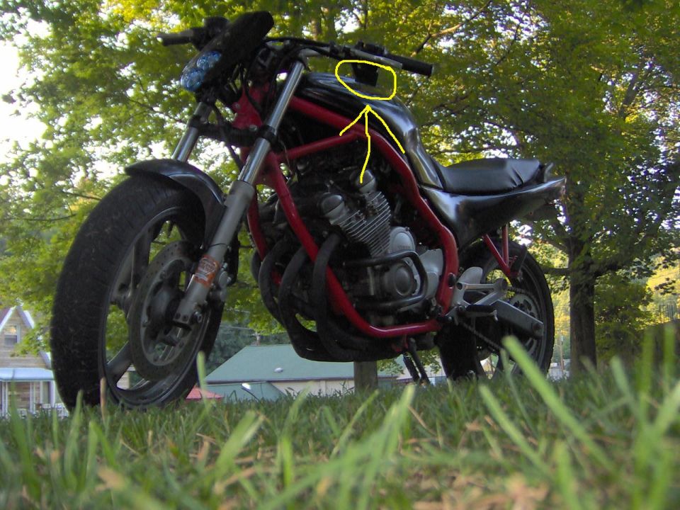 Red frame motorcycle with black tank and seat, viewed from low angle