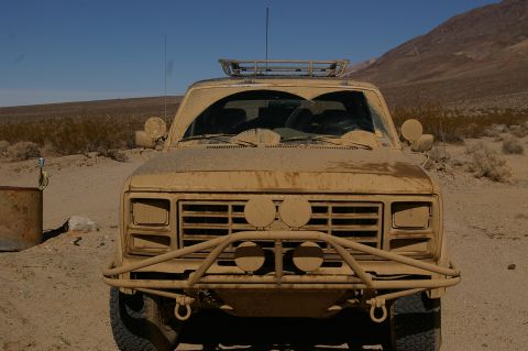 1986 Ford Bronco - This dusty 1986 Ford Bronco is equipped with an off-road bumper and roof rack, ready for desert exploration.
