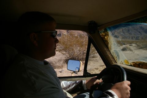 1986 Ford Bronco - Driver navigates a desert landscape from the interior of a 1986 Ford Bronco.