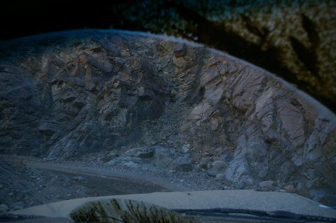 1986 Ford Bronco - View from inside a vehicle looking out at a mountain landscape and a dirt road.