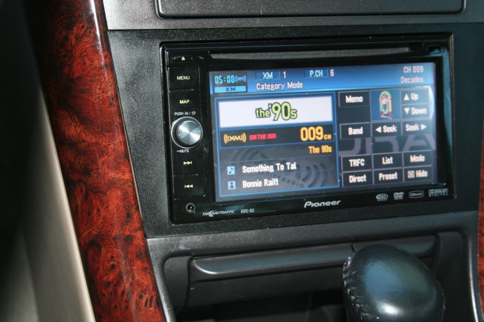 Pioneer AVIC-D3 head unit showing XM radio channel 009 The 90s in a wood-trimmed dash