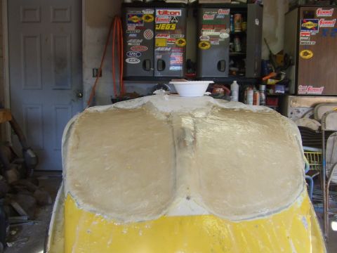 1998 Kawasaki JH1100-A4 1100 ZXi - A jet ski hull is being repaired with fiberglass in a garage setting. Tool cabinets are visible in the background.