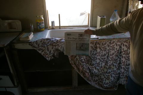 1986 Ford Bronco - A person holds a newspaper in front of a sink in a dimly lit room.