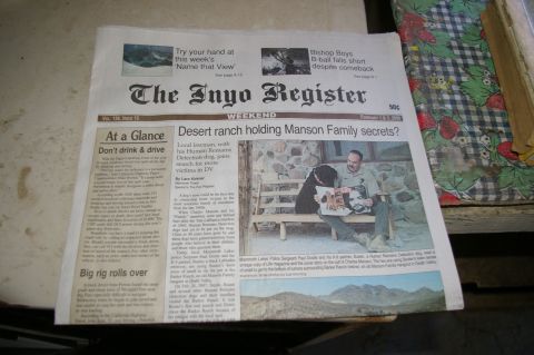 1986 Ford Bronco - A newspaper titled 'The Inyo Register' is spread open, displaying headlines and images related to a desert ranch and the Manson Family.