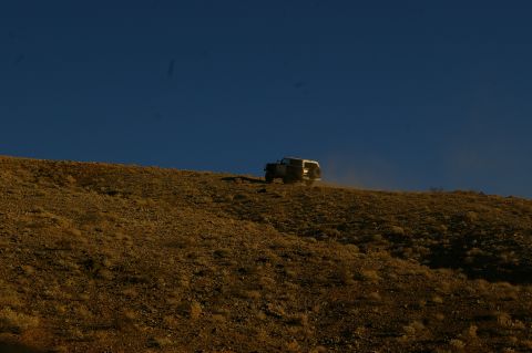 1986 Ford Bronco - Bronco kicks up dust on a desert hill climb.