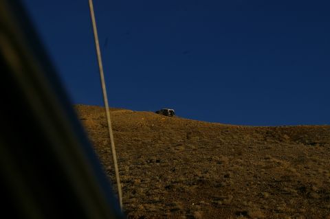 1986 Ford Bronco - A lone SUV is parked on a barren hillside.