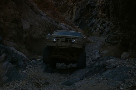 1986 Ford Bronco - Off-road vehicle navigates a challenging rocky path through a narrow canyon.