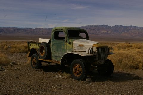 1986 Ford Bronco - An abandoned truck sits in a desolate landscape under a cloudy sky.