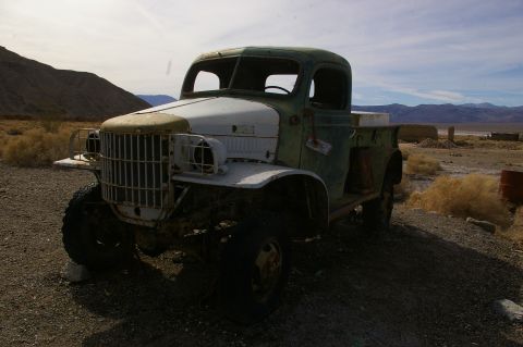 1986 Ford Bronco - An abandoned truck sits in a desolate, arid environment under a cloudy sky.