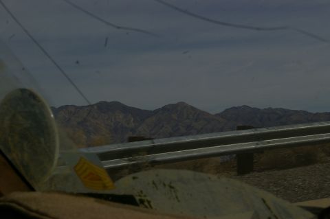 1986 Ford Bronco - View from inside a vehicle, looking out at a mountainous landscape and a roadside guardrail.