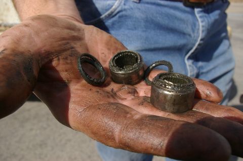 1986 Ford Bronco - Worn bearing parts held in a grease-covered hand.