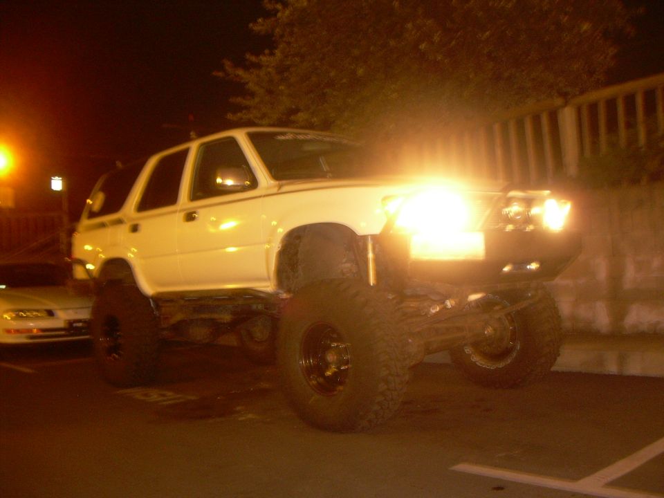 Lifted 1993 Toyota 4Runner with large off-road tires parked at night