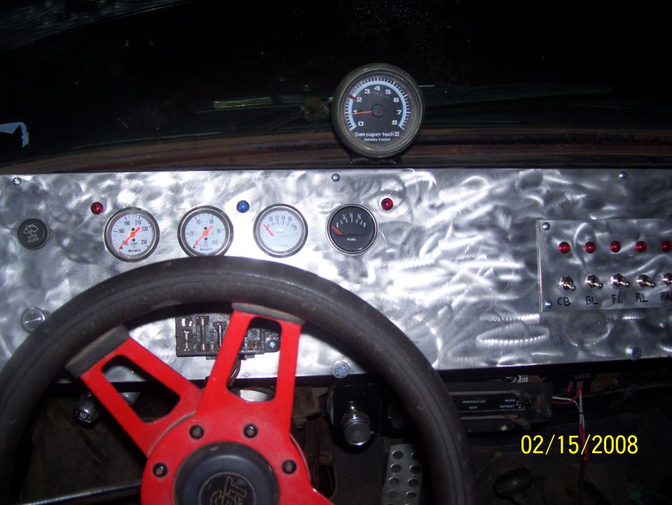 Custom dashboard with a red steering wheel, multiple gauges, and toggle switches