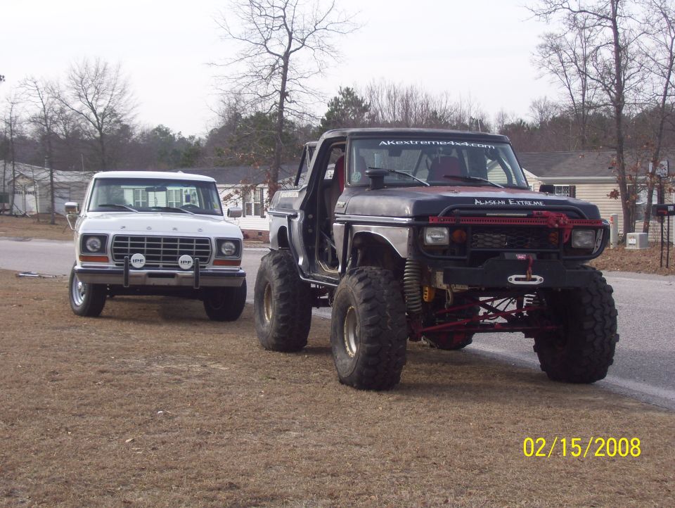 1978 Ford Bronco and a heavily modified black Ford truck with large tires