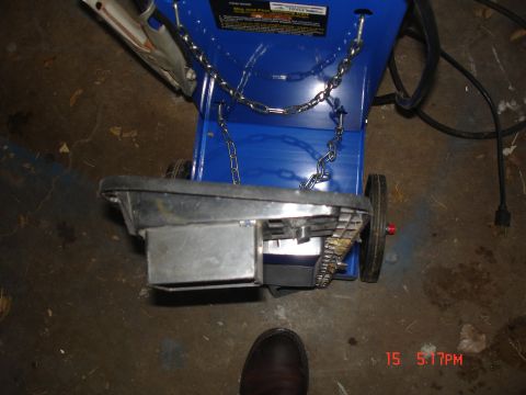 1979 Ford Bronco - A blue chipper shredder is shown with chains and wheels on a concrete floor.