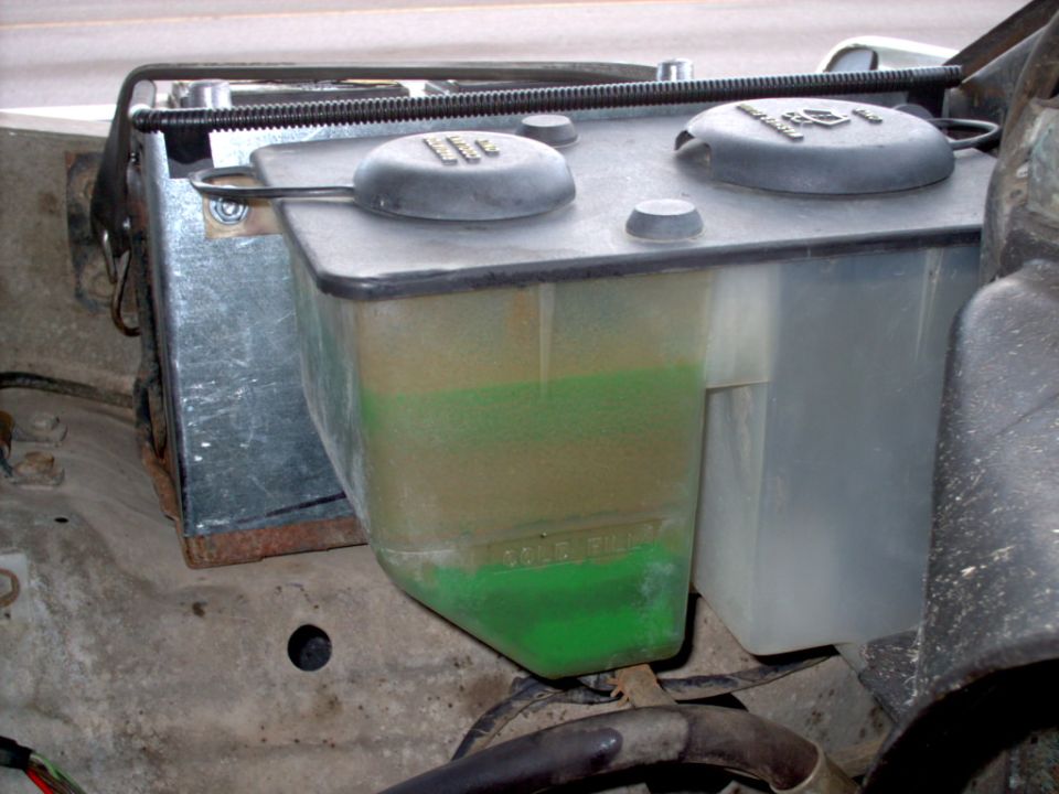 Windshield washer fluid reservoir with green fluid, "FULL" marking visible