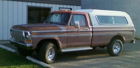 1979 Ford F-250 - This Ford pickup truck, likely from the late 1970s, is shown with a white camper shell covering the bed.