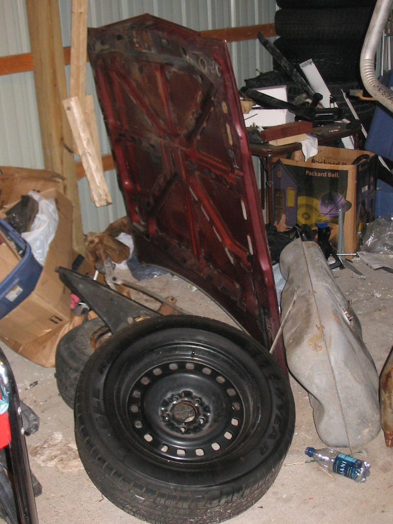 Hood, fuel tank, and wheel.  I got this set of '98 cop wheels, complete with good used Eagle RS-A tires, for $200 from a Crownvic.net member in the Indy area.  They'll be the first addition to the new car.  Ask my pal torquelover from Grandmarq.net, 16" cop rims on a black sedan just plain work.
