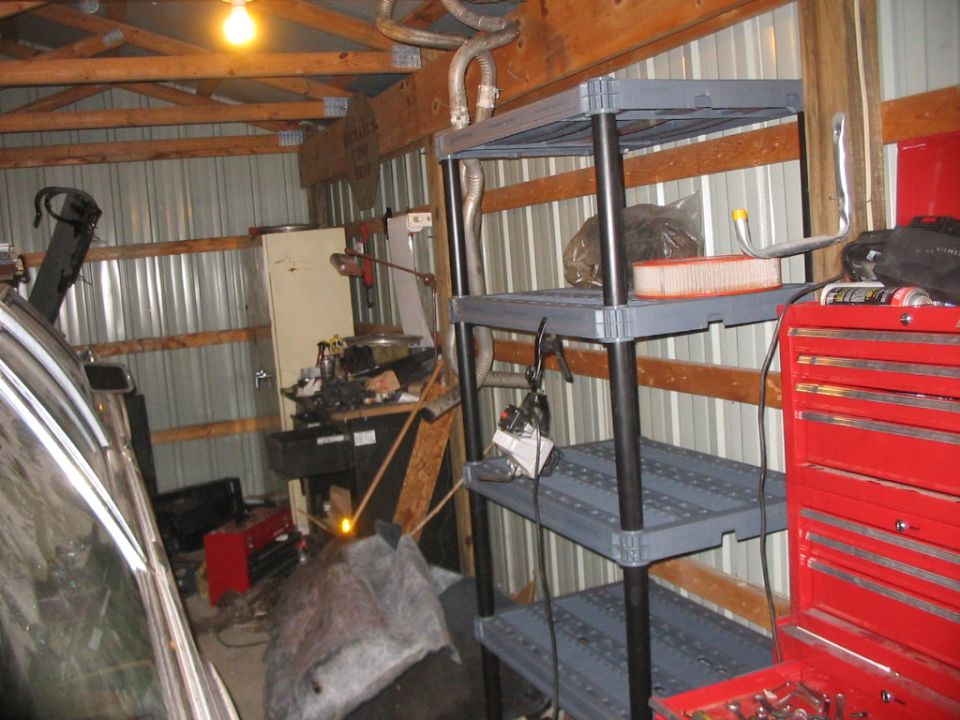 Second view of the same wall, showing the workbench and an old storage cabinet back in the corner.