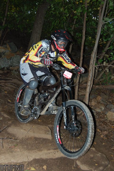 1976 Toyota Land Cruiser - Rider navigates a challenging downhill mountain bike trail through a wooded area.