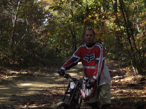 1976 Toyota Land Cruiser - A man poses with his dirt bike on a trail surrounded by autumn foliage.