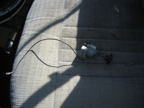 1981 Ford Bronco - Distributor cap and rotor are placed on a car seat, possibly for storage or repair.