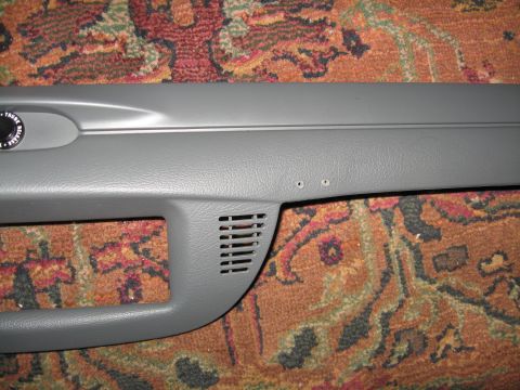 2004 Ford Crown Victoria - A section of car interior trim, possibly from a dashboard or door panel, is shown against a patterned carpet.
