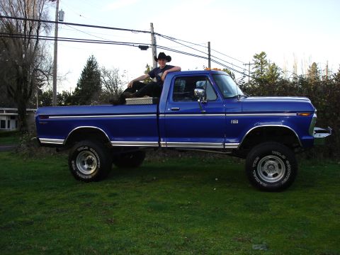 1973 Ford F-250 - A blue 1973 Ford F-250 pickup truck is shown from the side, with a person sitting on the tailgate.