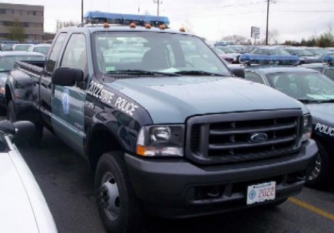 1991 Ford Crown Victoria - Ford F-350 Super Duty dually truck marked for state police duty, parked among other vehicles.