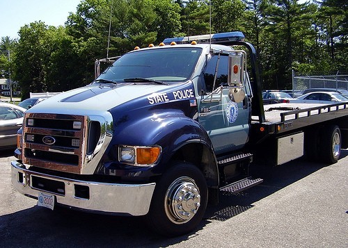 Ford F-series tow truck with 'STATE POLICE' on the side, license plate reads '2002'