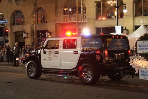 1991 Ford Crown Victoria - A Hummer H2 SUV serves as a police vehicle, equipped with emergency lights and markings.