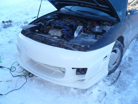 1993 Ford Probe - A car with a custom body kit and its hood open is parked in the snow, showing its engine.