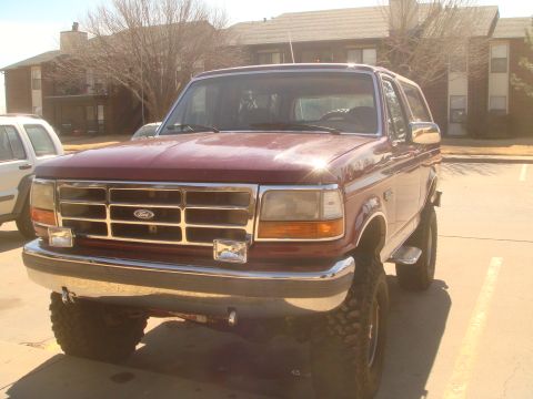 1992 Ford Bronco - This red 1992 Ford Bronco features a prominent chrome grille and square headlights.
