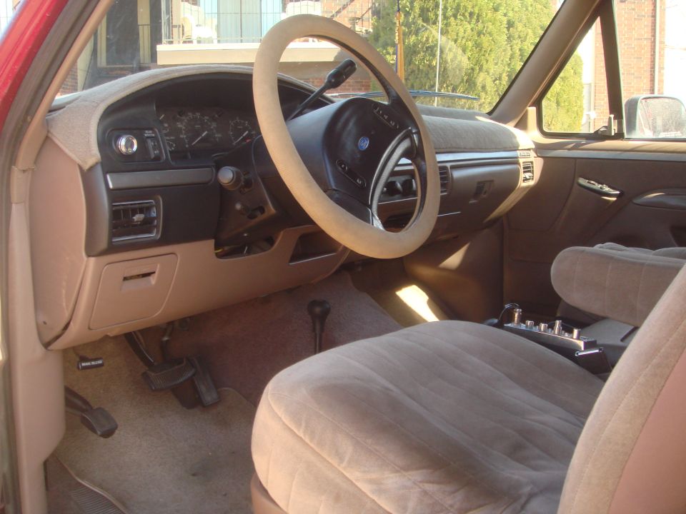 1992 Ford Bronco interior with tan seats, dashboard, and steering wheel cover