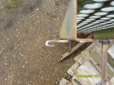 1989 Ford Bronco - A metal grate with a hook is shown outdoors on a gravel surface, with a timestamp in the corner.