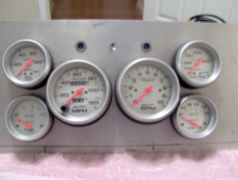 1978 Ford Bronco - A collection of aftermarket gauges mounted on a metal panel.