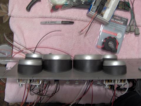 1978 Ford Bronco - Dashboard gauges and wiring are laid out with tools, including a tape measure and marker.