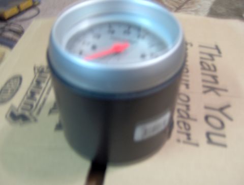 1978 Ford Bronco - A gauge with a red needle is placed on a box with text.