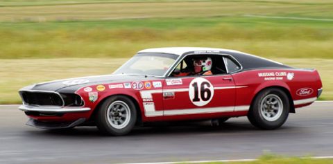 1981 Kawasaki Bayou - This 1969 Ford Mustang Boss 302 race car is on the track, displaying sponsor decals and the number 16.