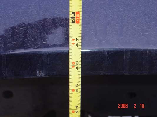 Yellow tape measure showing about 46-47 inches against a dark blue vehicle body panel edge