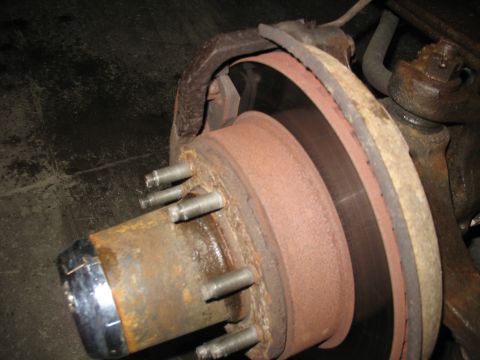 1995 Ford C-350 (Centurion Conversions) - This image shows a close-up view of a vehicle's wheel hub and brake assembly, highlighting the rusty components.
