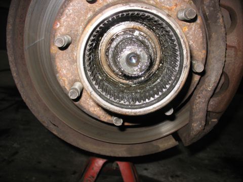 1995 Ford C-350 (Centurion Conversions) - Close-up of a vehicle's front wheel hub and brake assembly, showing internal mechanical components.