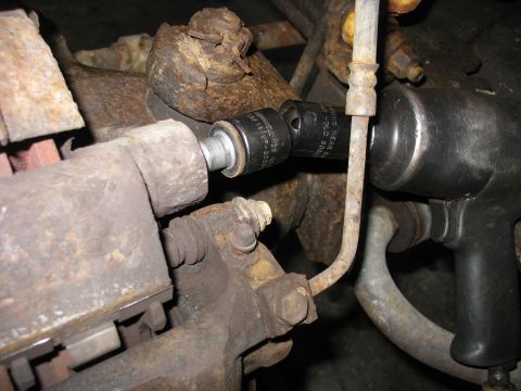 1995 Ford C-350 (Centurion Conversions) - Using an impact wrench to remove a bolt from a vehicle's brake caliper during a front axle rebuild.