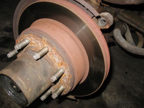 1995 Ford C-350 (Centurion Conversions) - This image shows a heavily corroded wheel hub and brake rotor assembly, likely from a truck or heavy-duty vehicle.